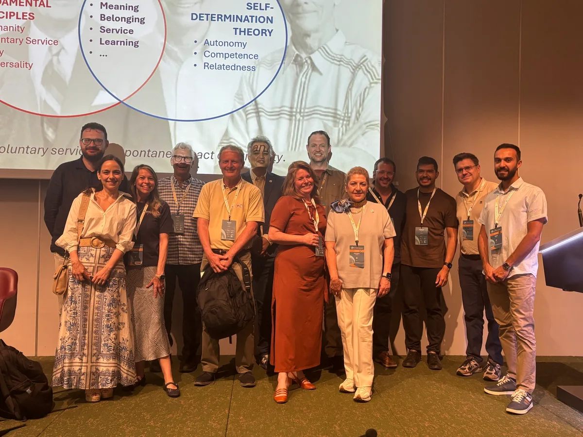 Presenters and attendees gathered on stage with Richard Ryan beneath a slide about Self-Determination Theory